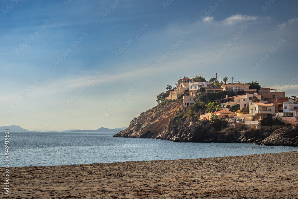 Bolnuevo beach, romantic coastal landscape with houses on a hill, Spain