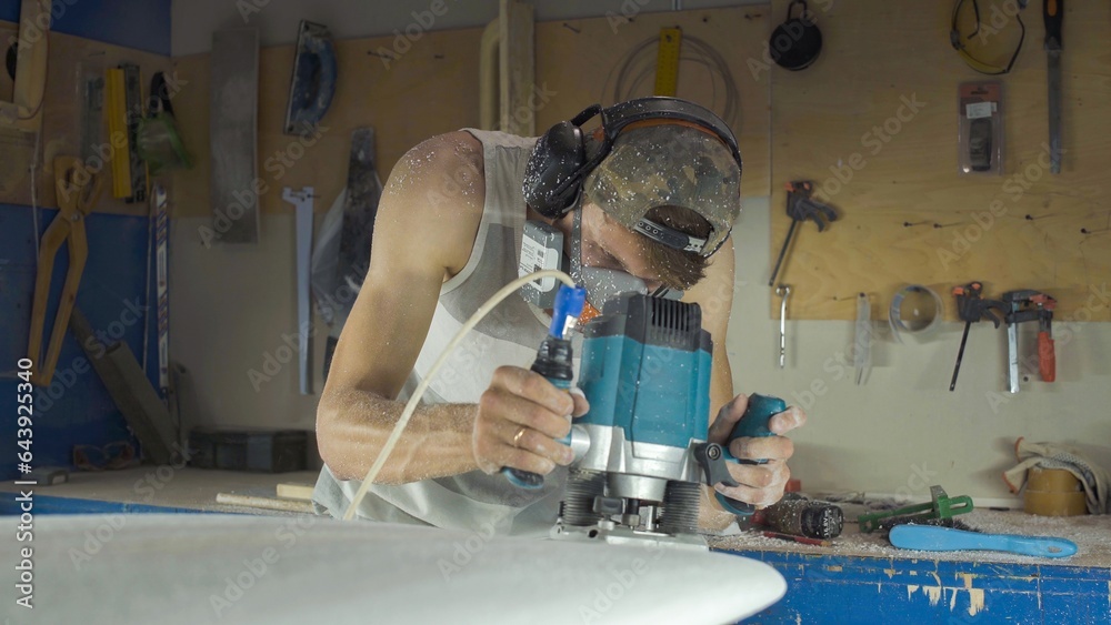 Male surfboard shaper making surfboard in his workshop. Hand shaping from blank. Male surfboard shaper making surfboard in his workshop. Hand shaping from blank.