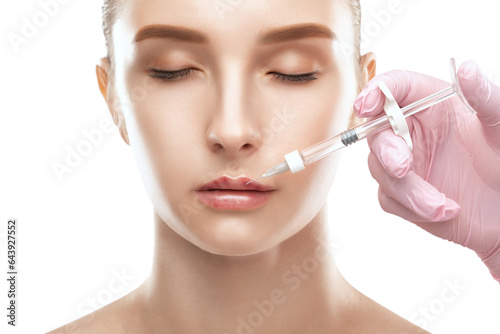Cosmetologist does injections for lips augmentation anti wrinkle injections on the face of a beautiful woman. Female aesthetic cosmetology in a beauty salon.