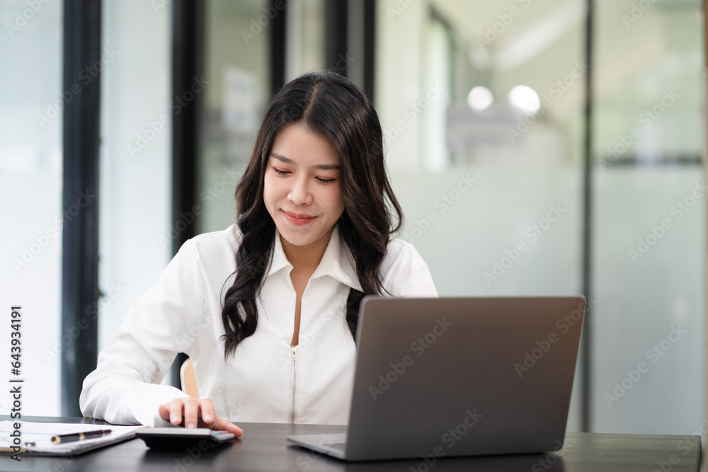 Women are using calculators to calculate office income.