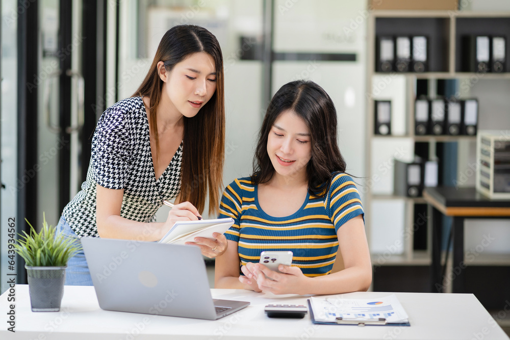 Lifestyle of office workers Two Young Woman calculating expenses and using laptop. Home office. Work place. Lifestyle.
