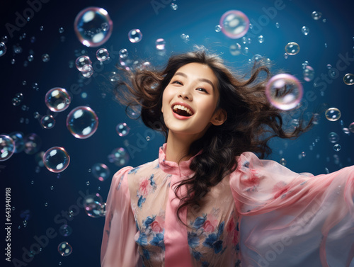 Woman enjoying being surrounded by bubbles, blue background, fun and cute, summer feeling