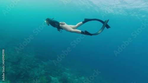 Wallpaper Mural Female freediver swims underwater and explores vivid and healthy coral reef in Komodo National Park in Indonesia Torontodigital.ca