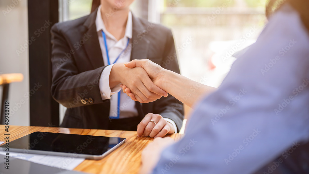 Obraz premium Close-up image of a businesswoman shaking hands with her client or colleague after a meeting.