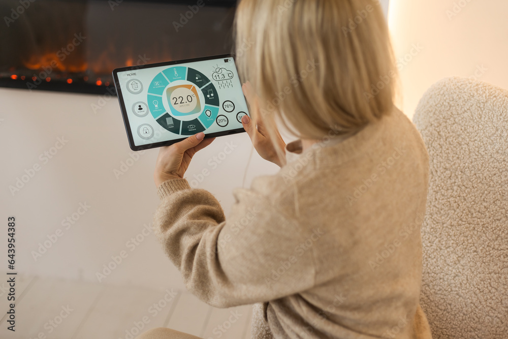A woman holding a tablet with smart home screen