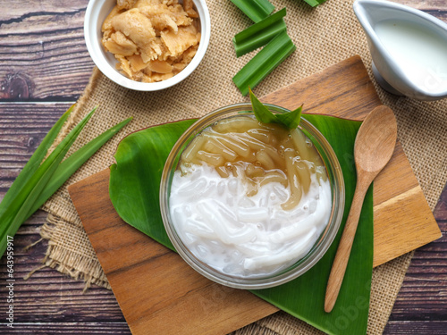 Pla Krim Khai Tao - Thai dessert of sweet rice noodles in palm sugar and in coconut cream,  flat lay food on wood table
