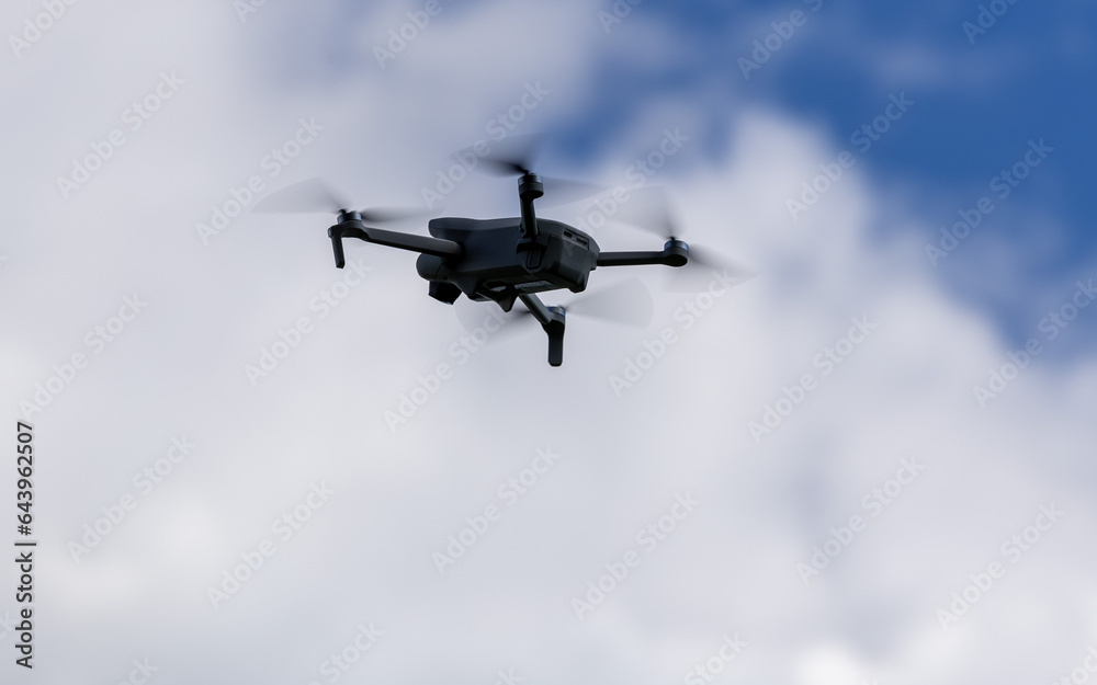 drone hovering in a bright blue sky. New technology in the aero photo shooting. drone hovering in a bright blue sky. New technology in the aero photo shooting.