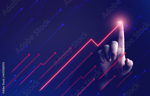 Businessman's hand showing rising arrow on dark background. concepts of business that express the development or increasing business opportunities and more profits