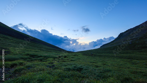 Distant storm clouds in quiet valley near Mt. Asahidake summit at blue hour © Osaze