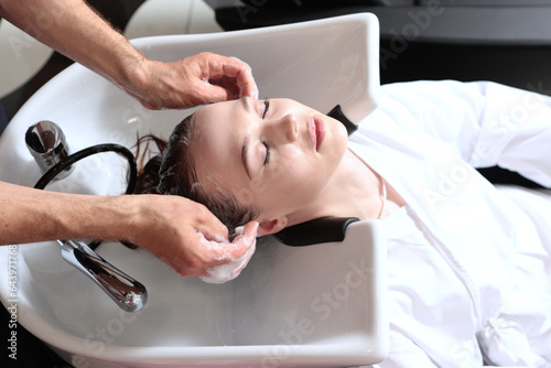 Woman washes her hair in spa salon or barber shop. Concept of spa services.Fashion lifestyle.