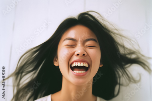 A content young woman, wrapped in earth tone attire, green gray and brown, bursts into laughter against a studio backdrop. Her carefree expression radiates warmth and comfort. Generative AI