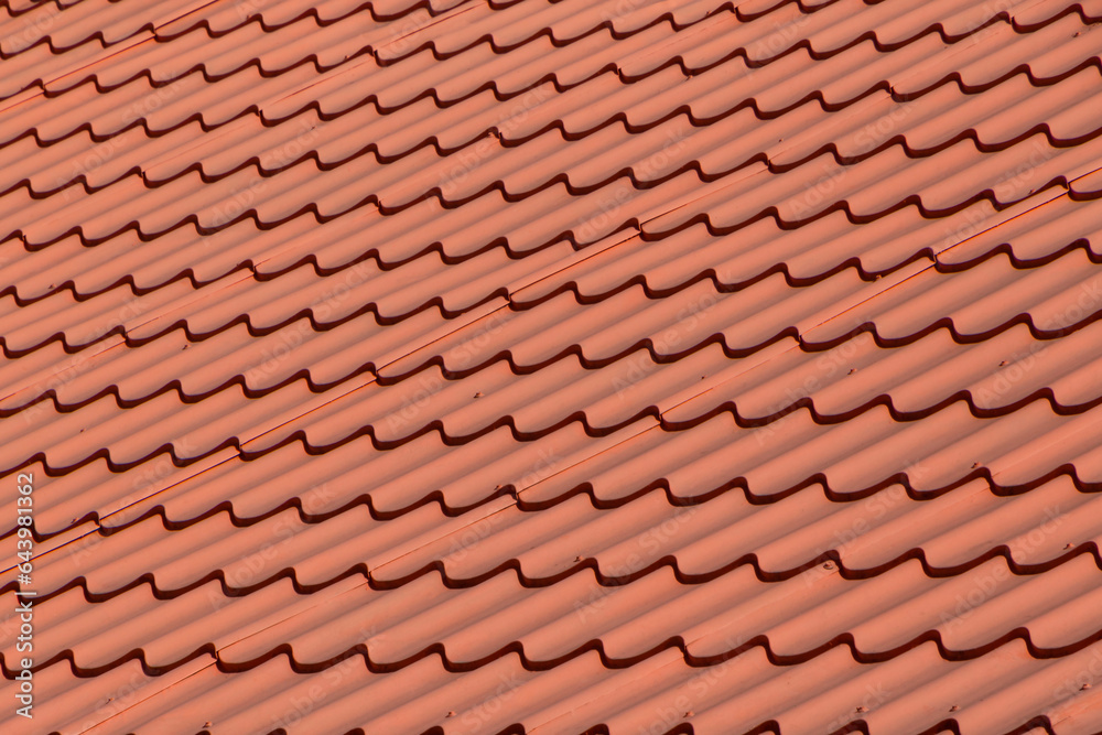close up of roof of house covered with red metallic tiles