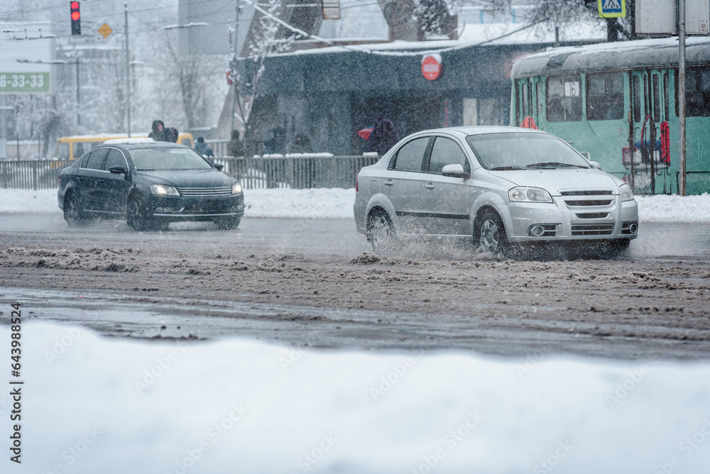 Cars riding on snow covered road in city during snowstorm, Vehicles gracefully traversing snow-blanketed city streets amidst a fierce winter storm.