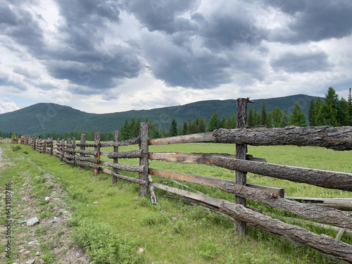 Fototapeta Naklejka Na Ścianę i Meble -  Wooden fence on the background of mountains in the Altai Republic
