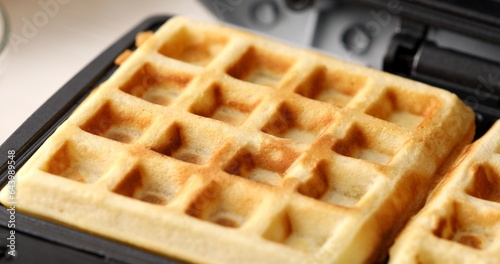 Belgian waffle in a waffle iron close-up. High quality photo