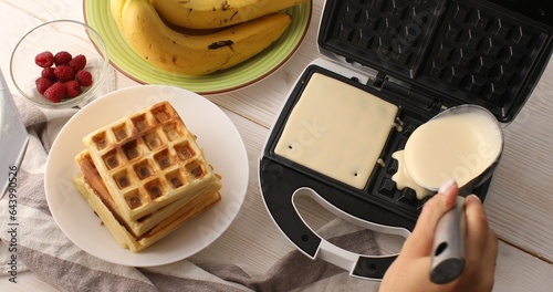 Liquid dough poured waffle iron machine to prepare Belgian waffle. Food preparation. Close up shot. 