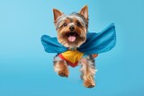 Headshot portrait photography of a smiling yorkshire terrier doing zoomies wearing a superhero cape against a pastel blue background. With generative AI technology
