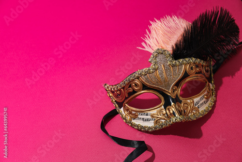 Carnival mask with feathers on pink background, space for text
