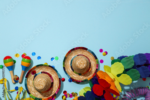 Confetti, marocas and hats on blue background, space for text