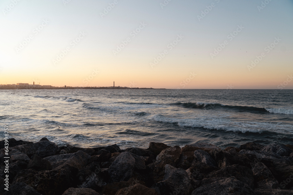 view of El Hank Lighthouse seen from Hassan II Mosque at sunset - Casablanca, Morocco