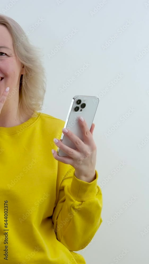 surprise embarrassment shame woman in orange yellow sweater stands in hands with phone shy closes eyes blushes reddened face clamp teeth touch head surprise embarrassment shame woman in orange yellow sweater stands in hands with phone shy closes eyes blushes reddened face clamp teeth touch head