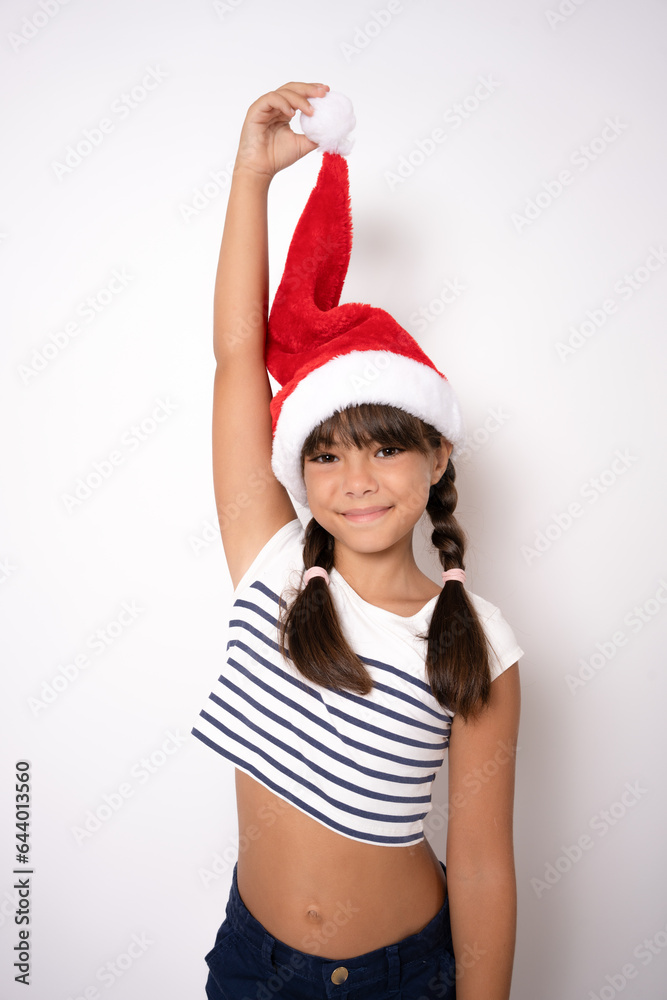 Cute little girl in santa hat standing isolated over white background. Cute little girl in santa hat standing isolated over white background.