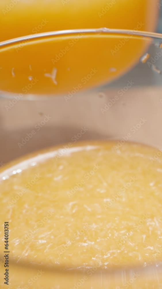 Vertical video. I slowly pour orange juice with pulp into the glass until it's full. Vertical video. I slowly pour orange juice with pulp into the glass until it's full.