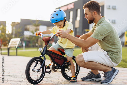 Father teaching his little son to ride a bicycle