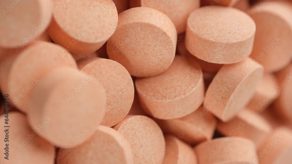 Orange pills vitamin C in white plate, rotation. Vertical video Orange pills vitamin C in white plate, rotation. Vertical video