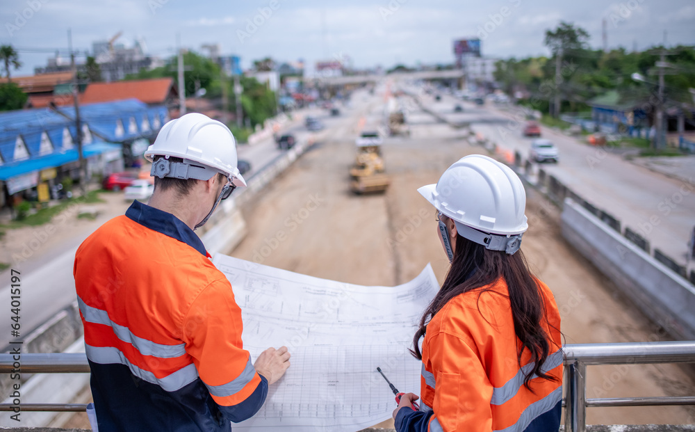 Engineers Surveyor wearing safety uniform ,helmet with equipment theodolite to measurement positioning on the construction site of the road with construct machinery background. Engineers Surveyor wearing safety uniform ,helmet with equipment theodolite to measurement positioning on the construction site of the road with construct machinery background.