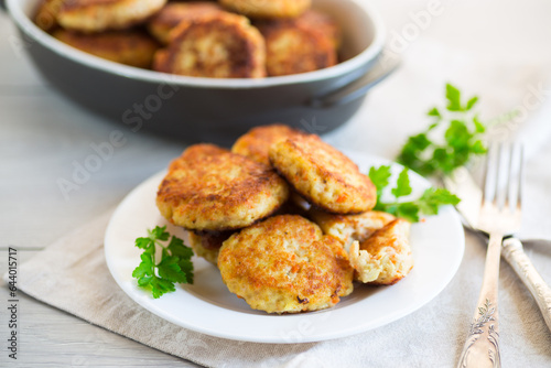 Cooked fried fish cutlets in a plate with herbs.