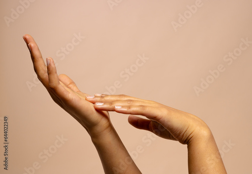 Touching hands of biracial woman on pink beige background with copy space