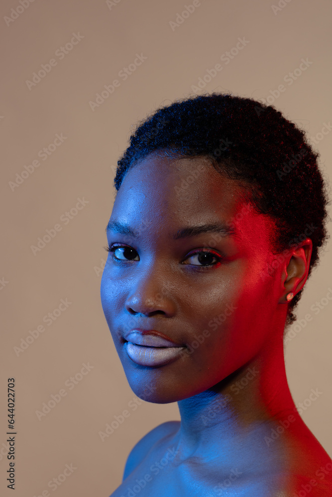 Smiling african american woman with short hair and white lipstick in blue and red light Smiling african american woman with short hair and white lipstick in blue and red light