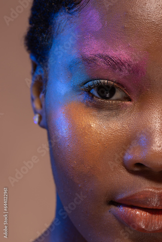 Half portrait of african american woman with short hair and colourful make up