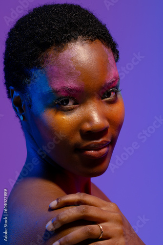 African american woman with short hair and colourful make up with hand on shoulder