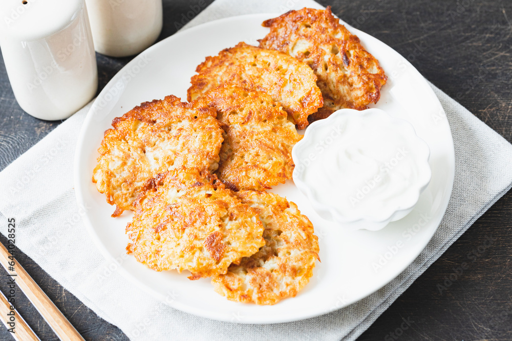 Potato pancakes or latkes or draniki with sour cream. Ukrainian food. A grated potato dish of Deruny or Draniki