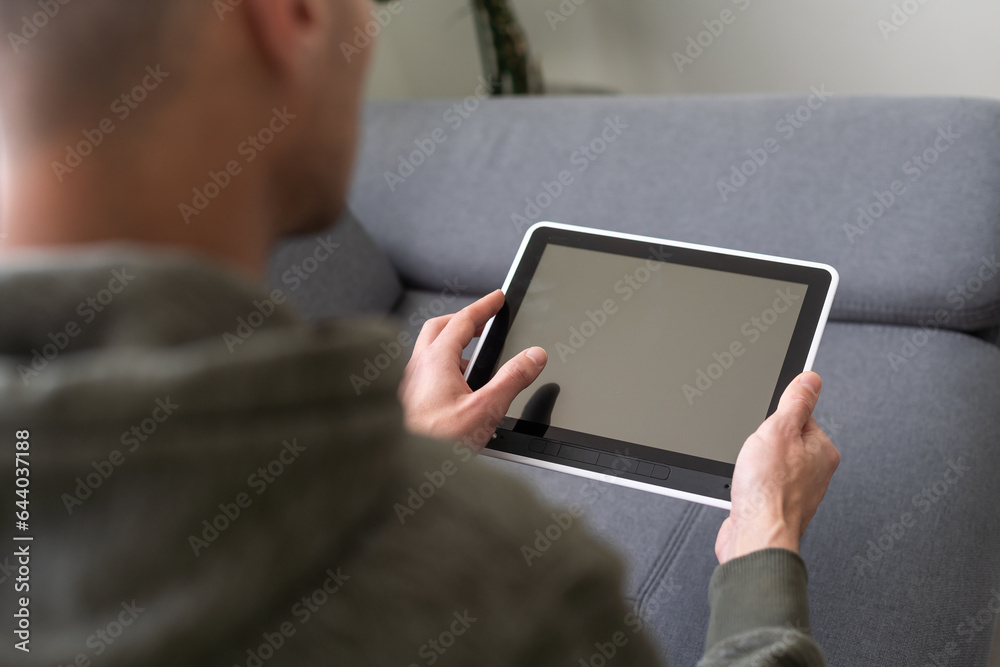 Digital tablet computer with isolated screen in male hands over cafe background