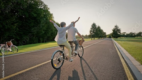 Elder couple traveling on riding path with double bicycle