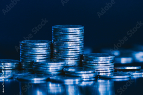 close up pile of money coin and stack on black background with blue filter. Business and finance background concept.