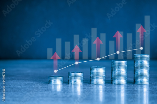 up stack of money coin with graph and red up arrow. Business and finance background concept with blue filter.