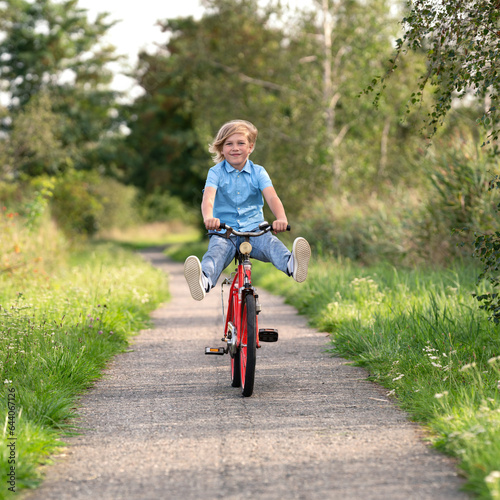 Fototapeta Naklejka Na Ścianę i Meble -  lachender Junge fährt mit Spaß Fahrrad