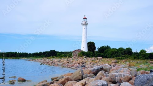 Scenic landscape with a lighthouse and a coastal shoreline on a clear sunny day photo