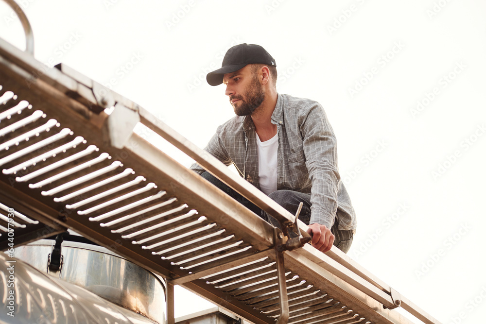Big fuel tanker. Young truck driver in casual clothes