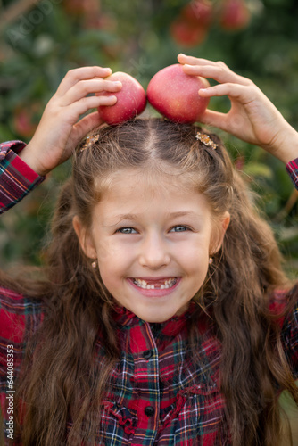 girl is smiling with apples on her head