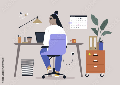A young character diligently using their computer at a desk, viewed from behind