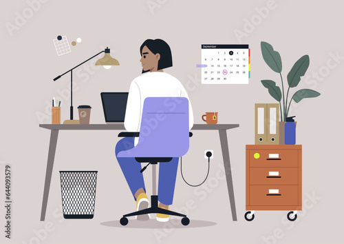A young character diligently using their computer at a desk, viewed from behind
