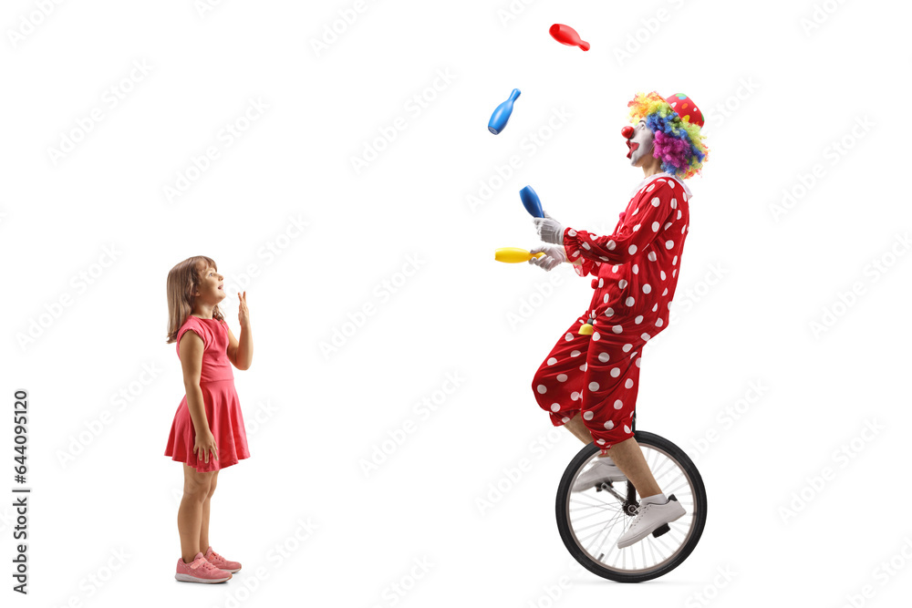 Full length profile shot of a surprised girl looking at a clown juggling and riding a unicycle Full length profile shot of a surprised girl looking at a clown juggling and riding a unicycle