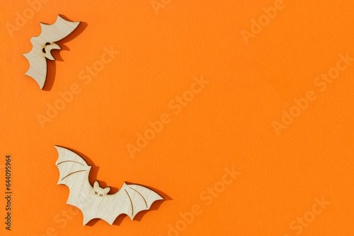 Wooden toy bats on orange background Halloween concept