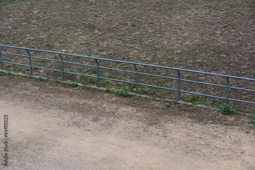 Dirt field pavement and metal railings © bqmeng