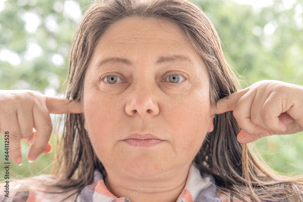 pretty caucasian woman 4045 years old plugged ears with her fingers